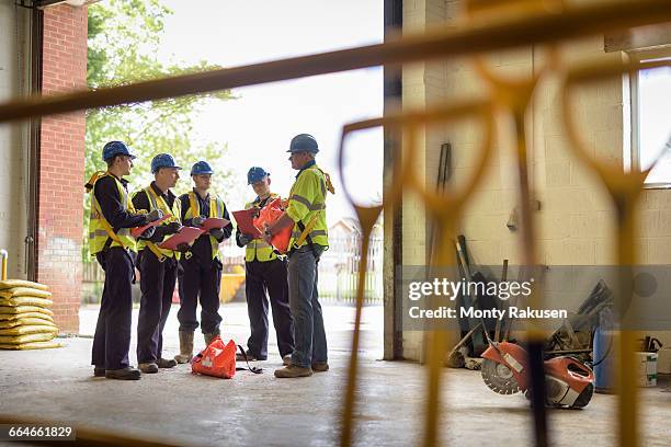 apprentice builders in presentation in training facility - werk in uitvoering stockfoto's en -beelden