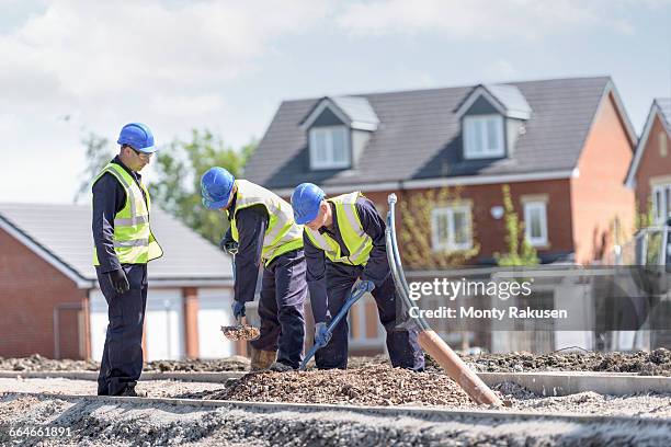 apprentice builders digging on building site - builder apprenticeship stock pictures, royalty-free photos & images