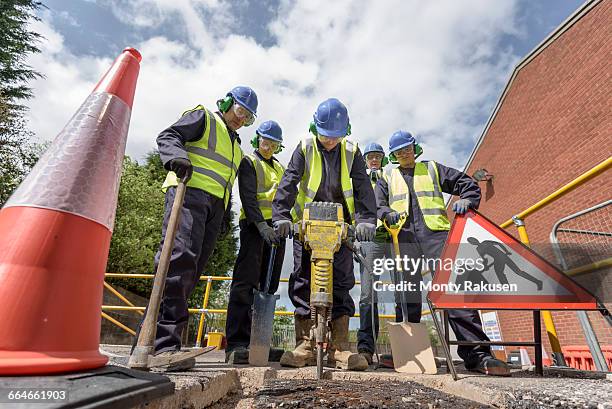apprentice builders training with pneumatic drill in training facility - presslufthammer stock-fotos und bilder