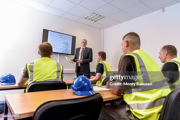 apprentice builders in presentation in training facility - misure di sicurezza foto e immagini stock