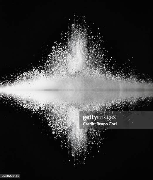 white dust exploding against mirror surface impact - émergence photos et images de collection