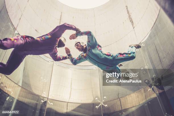 indoors skydiving -instructor teaching how to fly - freefall simulation - pose alternativa imagens e fotografias de stock