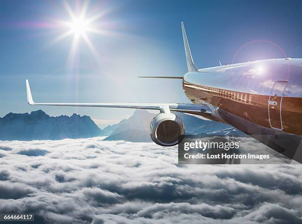 commercial jet flying over a sea of fog in the alps, canton wallis, switzerland - flugzeug sonne stock-fotos und bilder