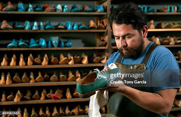 male cobbler in traditional shoe shop polishing green brogue - polishing shoes stock pictures, royalty-free photos & images