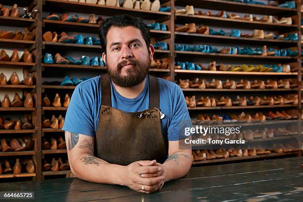 portrait of male cobbler at traditional shoe shop counter - sapateiro imagens e fotografias de stock