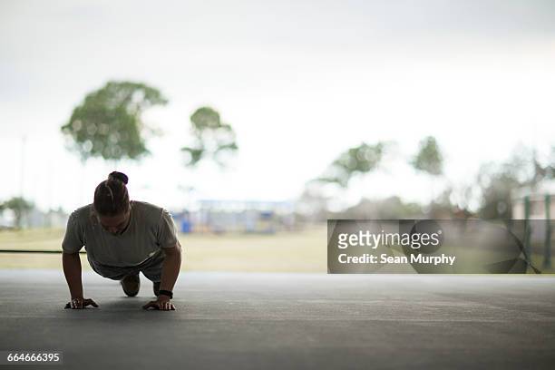 female soldier doing push ups at military air force base - us air force stock-fotos und bilder