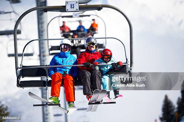 mother and two sons on ski lift - sessellift stock-fotos und bilder