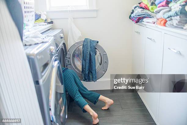 legs of boy in washing machine - abstellraum stock-fotos und bilder