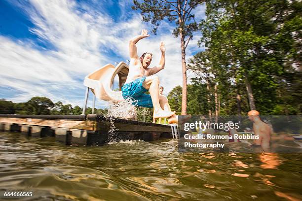 man jumping from pier slide at jackson lake, georgia, usa - atlanta georgia country stock pictures, royalty-free photos & images