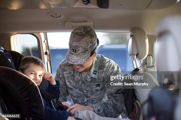 portrait of female soldier and son in car at air force military base - military base foto e immagini stock