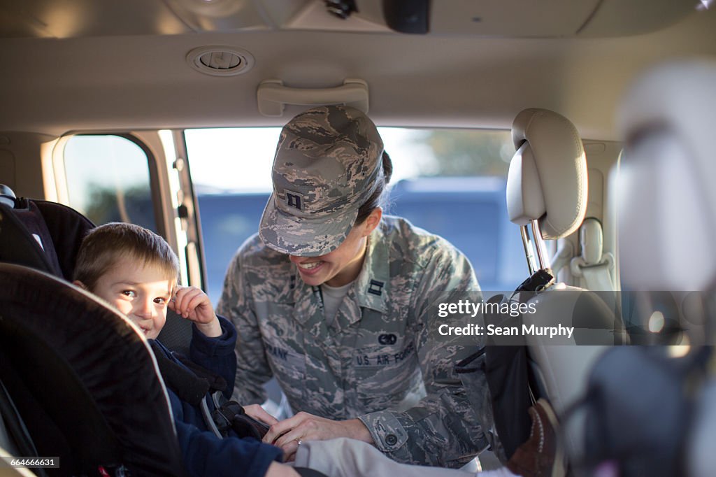 Portrait of female soldier and son in car at air force military base