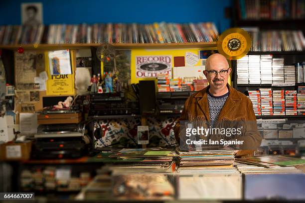 portrait of mature man in record shop, pricing up records using price gun - music shop stock pictures, royalty-free photos & images
