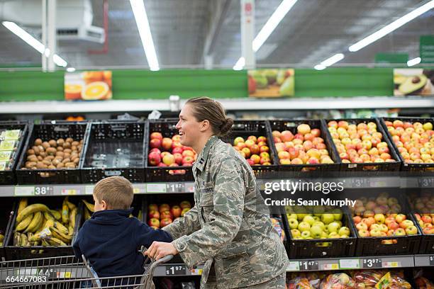 female soldier and son in supermarket at air force military base - military base stock-fotos und bilder