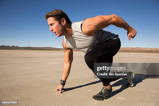 male runner on his marks on dry lake bed, el mirage, california, usa - el mirage photos et images de collection