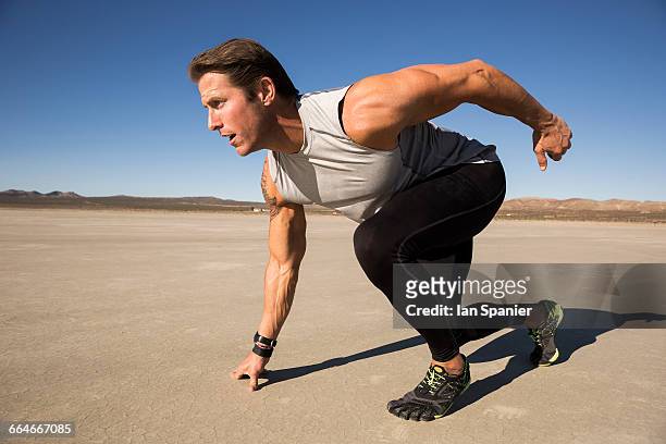 male runner on his marks on dry lake bed, el mirage, california, usa - el mirage stock pictures, royalty-free photos & images