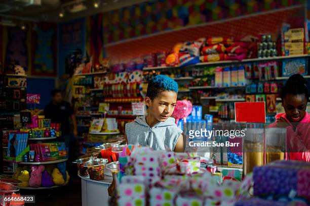 teenage boy and girl browsing in candy shop, brooklyn, usa - chocolatier photos et images de collection