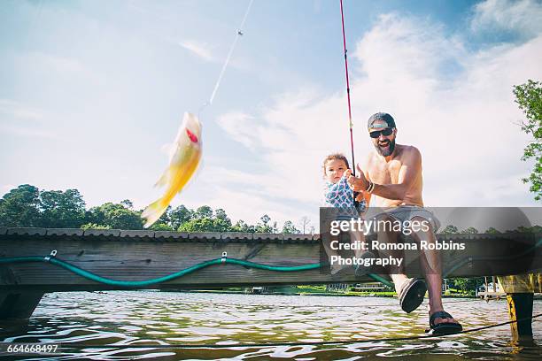 father and daughter reeling in fish at lake jackson, atlanta, georgia, usa - jackson lake (georgia) stock pictures, royalty-free photos & images