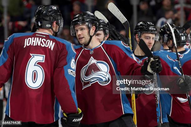 Erik Johnson of the Colorado Avalanche is congratulated by Cody Goloubef after scoring the winning goal against the Chicago Blackhawks at the Pepsi...