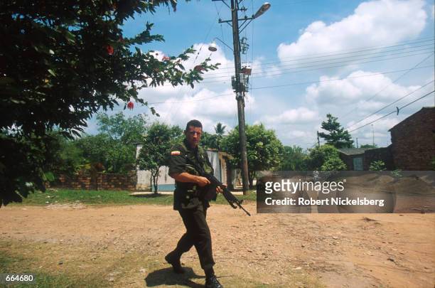 Federal Police officer patrols a FARC-controlled, barrio, or slum, August 21, 2000 of Barrancabermeja, Colombia. Barrancabermeja has the highest...