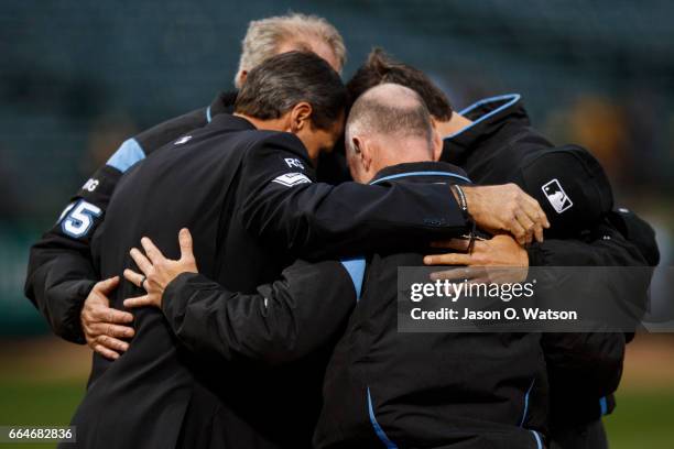 Umpires Angel Hernandez, Lance Barksdale, John Tumpane and Ted Barrett huddle before the game between the Oakland Athletics and the Los Angeles...