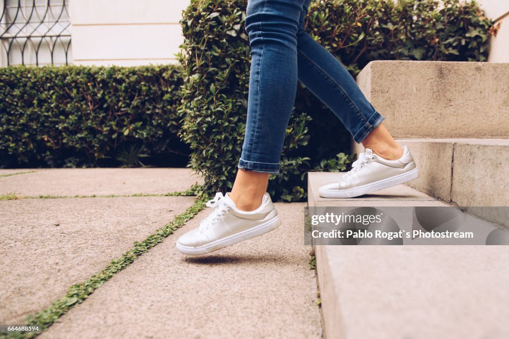 Legs of woman walking downstairs