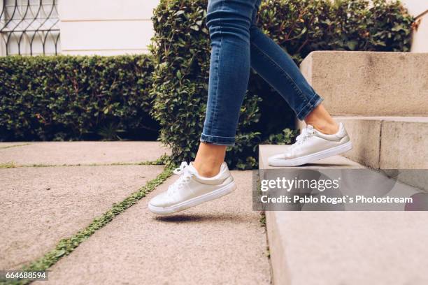 legs of woman walking downstairs - his foot stockfoto's en -beelden
