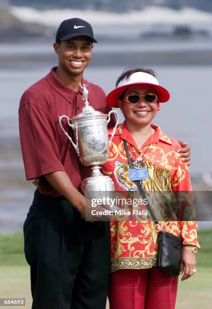 Tiger Woods and his mother Kultida pose with the U.S. Open trophy on the 18th green June 18, 2000 at Pebble Beach, CA. Woods became the first player...