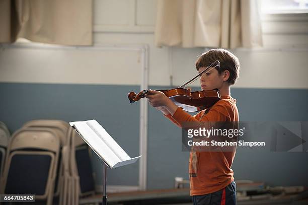 young boy intently practicing his violin - boy violin stockfoto's en -beelden