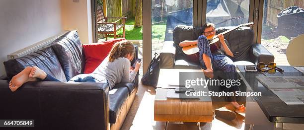 teens relax in sunny living room - teen girl barefoot at home stock pictures, royalty-free photos & images