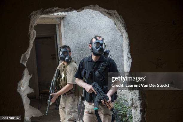 April 2013: Rebel fighters of Liwa Tarhir al Sham wear gas masks after a suspected chemical weapon attack by Syrian government forces in Jobar, a...