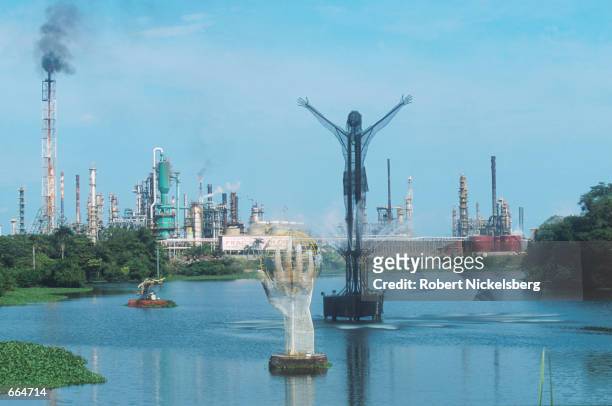 Sculptures protrude from the Magdalena River August 21, 2000 in front of Colombia's largest petroleum refinery, which supplies 70% of the nation's...