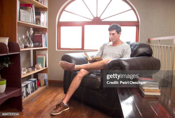 a young man in studies at home. - hourglass books fotografías e imágenes de stock