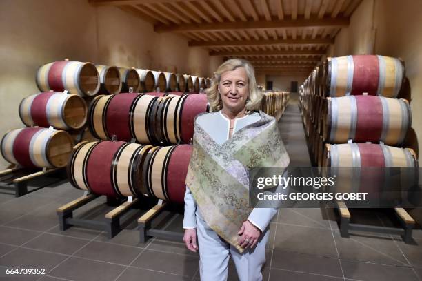 Sophie Schyler, one of the owners of the Chateau Kirwan walks past barrels in the wine cellar of the Chateau Kirwan, on March 31, 2017 in Cantenac....