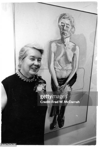 Portrait of American artist Alice Neel as she poses in front of one of her paintings at the Finch College Gallery, New York, New York, October 16,...
