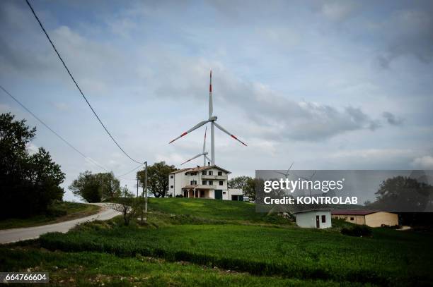 House with a very close wind tower in Montelongo wind farm in Molise, southern Italy. One of the biggest wind farms of southern Italy for the...