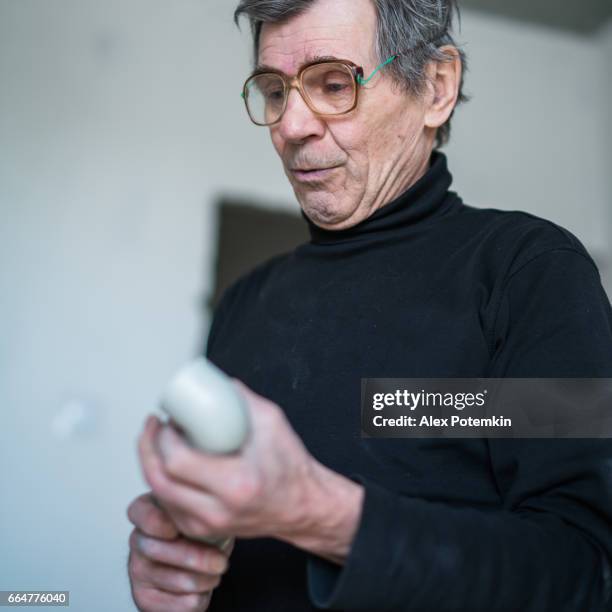 portret van de 70-jaar-oud actieve senior man, bouwvakker - loodgieter - bezig met verbinden stockfoto's en -beelden
