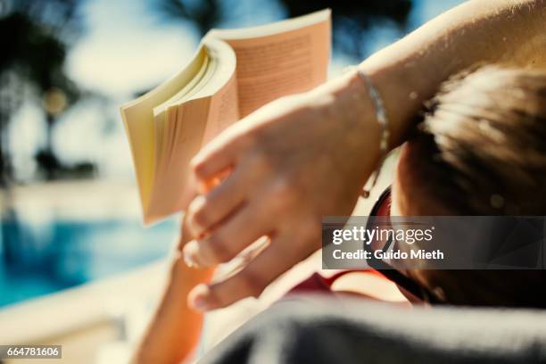 woman reading in book in sunlight. - libro verano fotografías e imágenes de stock