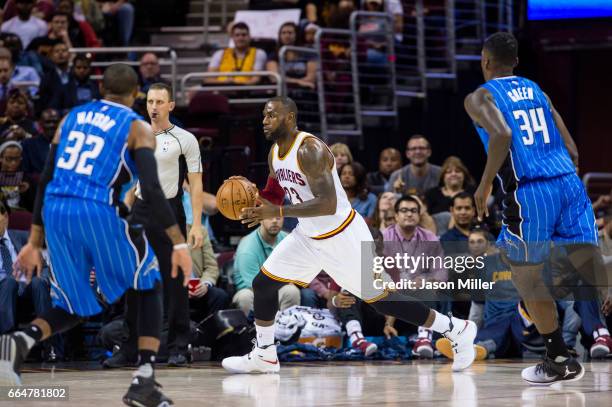 LeBron James of the Cleveland Cavaliers drives while under pressure from C.J. Watson of the Orlando Magic and Jeff Green during the first half of a...