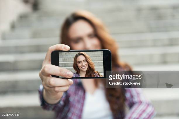 beautiful woman makes self portrait on smartphone view of screen - photography themes stock pictures, royalty-free photos & images