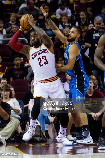 LeBron James of the Cleveland Cavaliers passes while under pressure from Evan Fournier of the Orlando Magic during the first half of a preseason game...