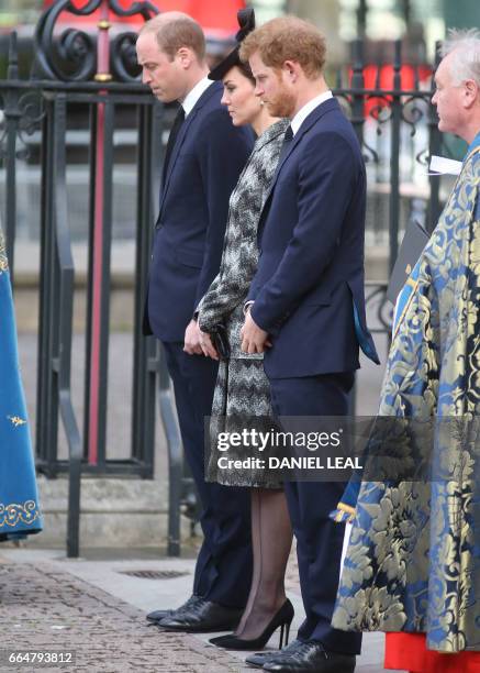 Britain's Prince William, Duke of Cambridge, Britain's Catherine, Duchess of Cambridge and Britain's Prince Harry stand during a wreath laying...