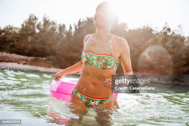 meisje in zwembad buis genieten van het spelen van wit haar moeder in het zeewater - zwemband stockfoto's en -beelden