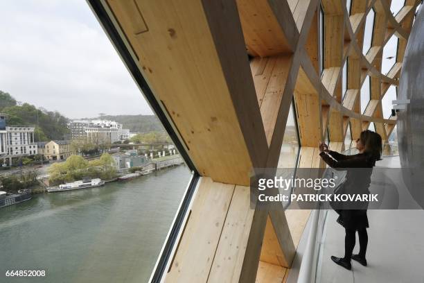 Visitor walks under the dome of the new 'La Seine Musicale' cultural and musical centre, designed by architects Shigeru Ban and Jean de Gastine, on...