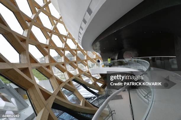 Visitors walk under the dome of the new 'La Seine Musicale' cultural and musical centre, designed by architects Shigeru Ban and Jean de Gastine, on...