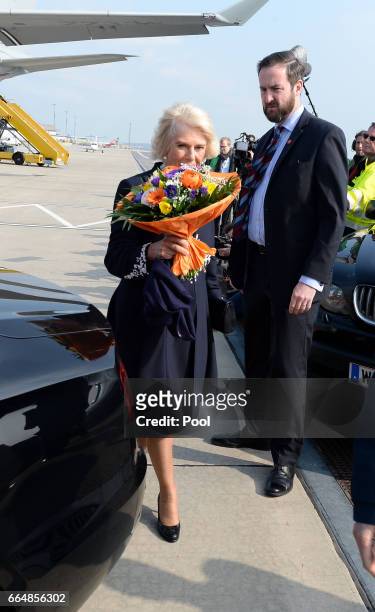 Camilla, Duchess of Cornwall holds some flowers as she arrives at the airport in Vienna on the eighth day of his European tour on April 5, 2017 in...