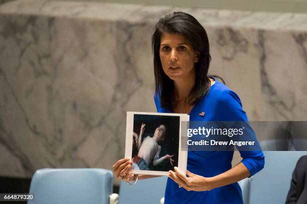 Ambassador to the United Nations Nikki Haley holds a photo of a victim of the Syrian chemical attack during a meeting of the United Nations Security...