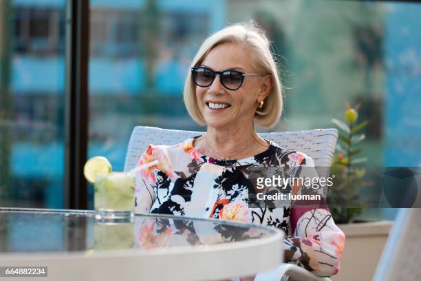 elegante oude dame drinken een caipirinha - confortável stockfoto's en -beelden