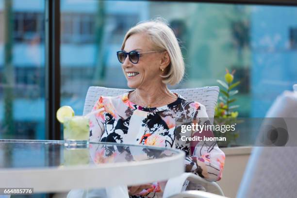 elegante dama de edad beber una caipirinha - contente fotografías e imágenes de stock