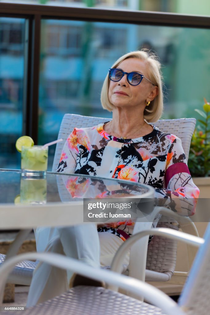 Elegant old lady drinking a caipirinha