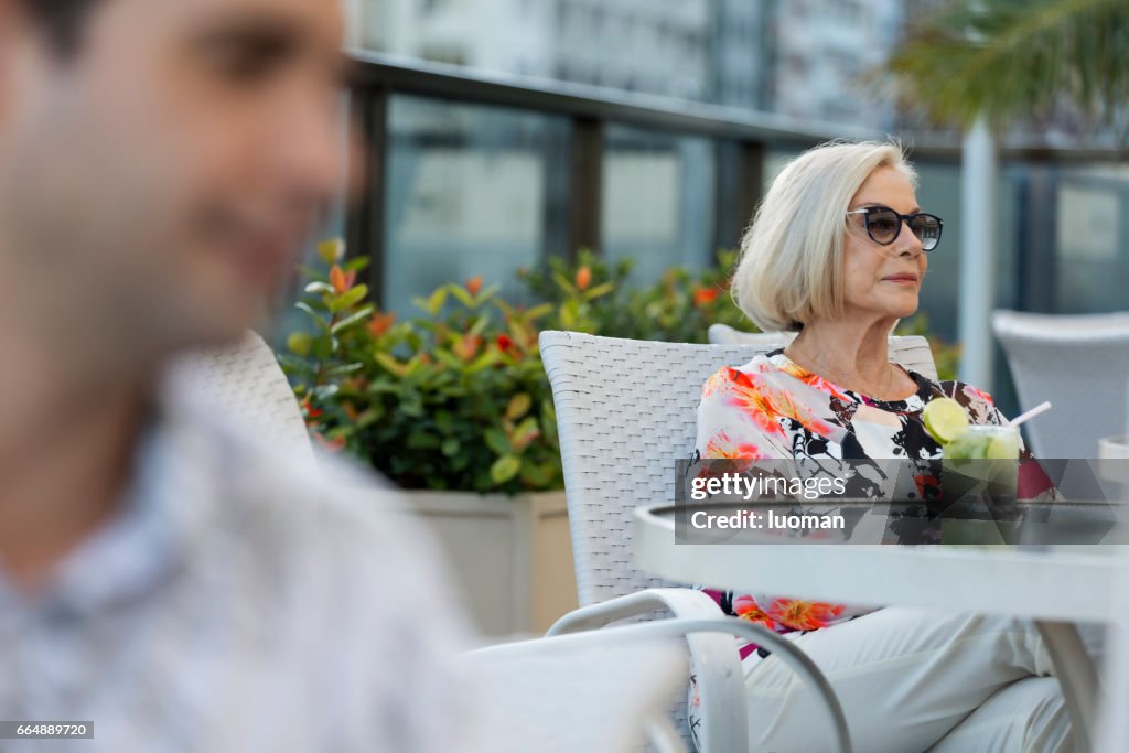 Elegante alte Dame einen Caipirinha trinken